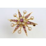 9ct gold hallmarked ruby and pearl star brooch. The brooch being set with a round mixed cut ruby