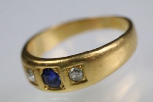 Synthetic blue spinel and diamond three stone ring set with a round cut blue synthetic spinel to