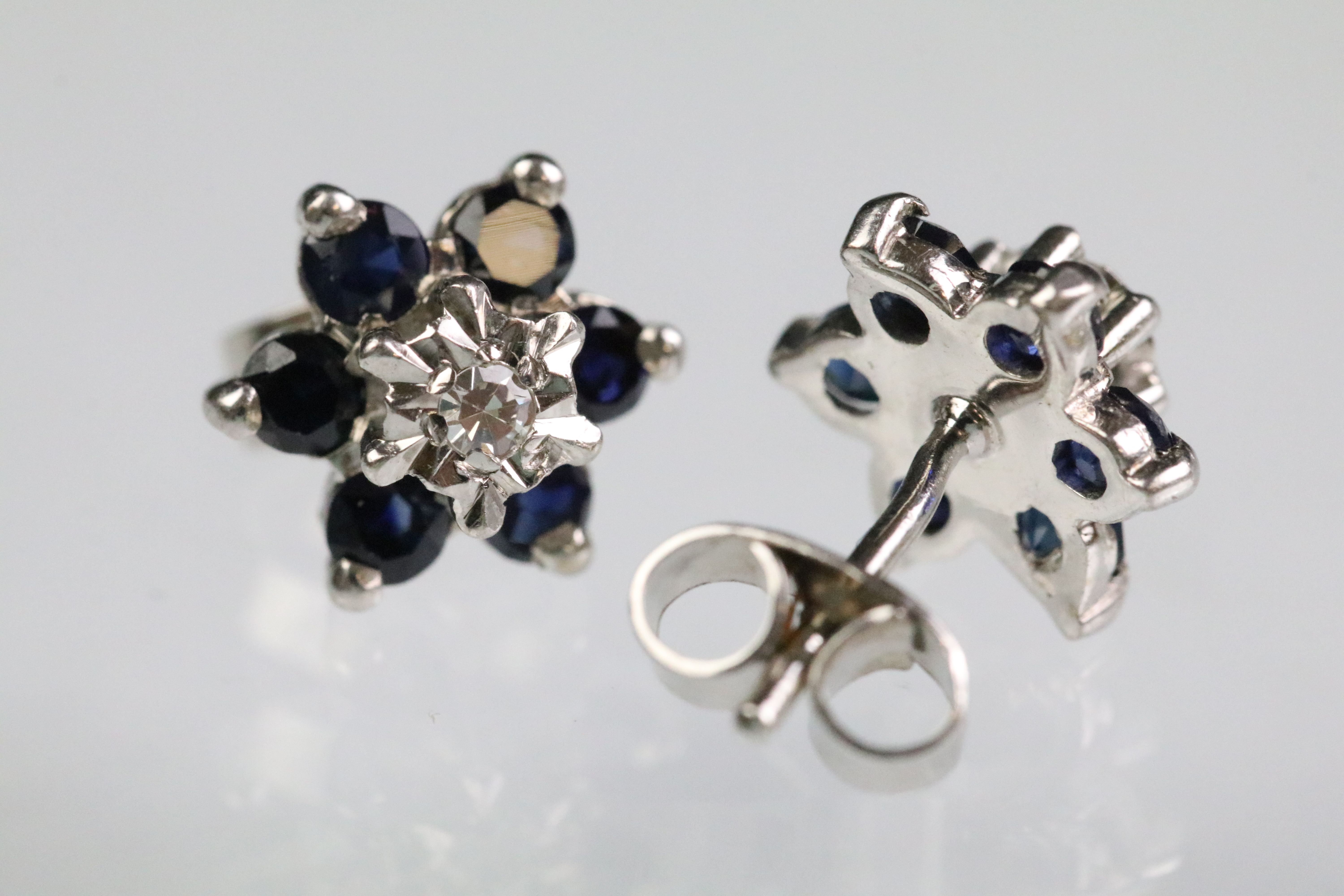 Sapphire and diamond cluster earrings having a central illusion cut diamond to centre with a hao