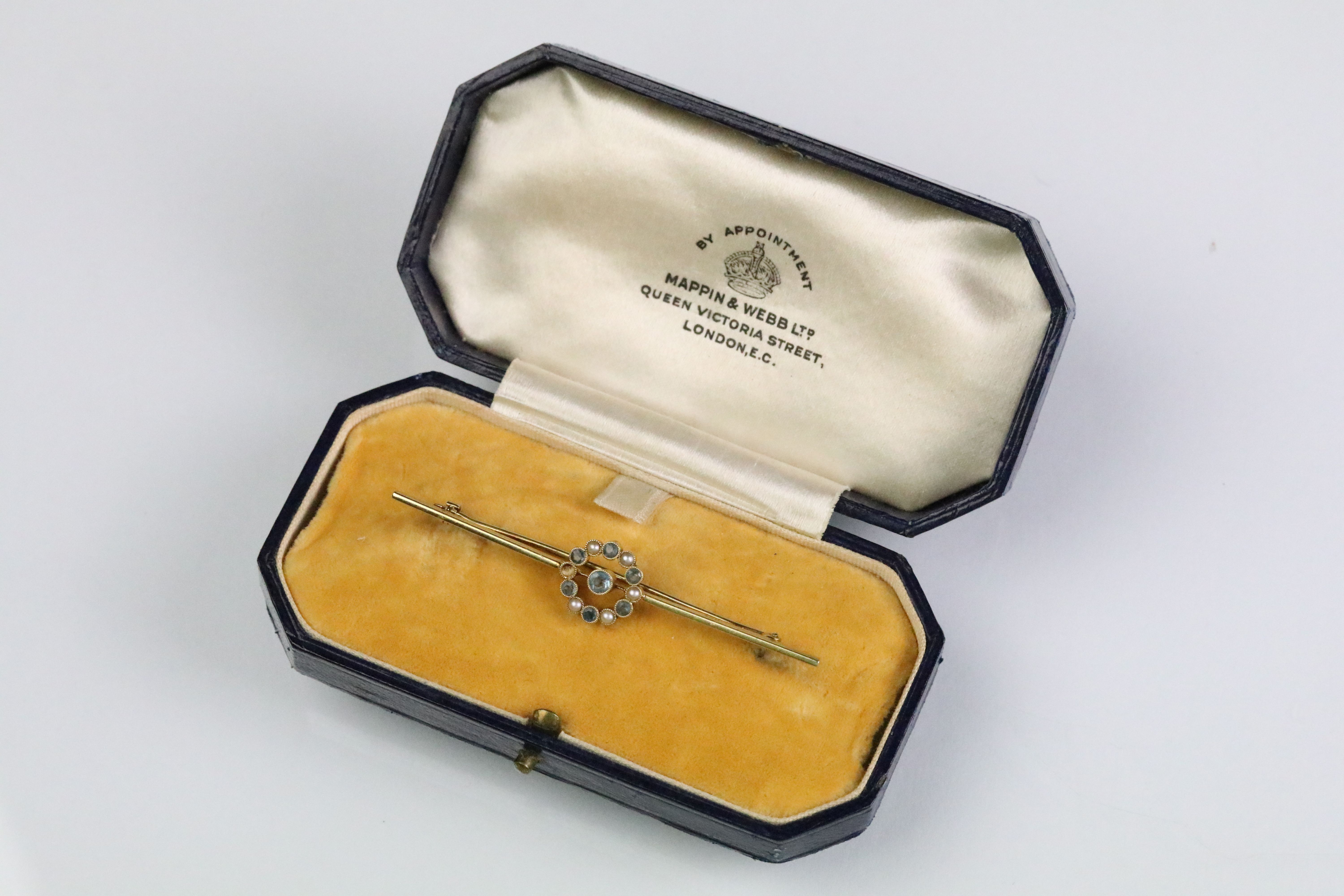 15ct gold aquamarine and pearl bar brooch. The brooch having a central millegrain set aquamarine
