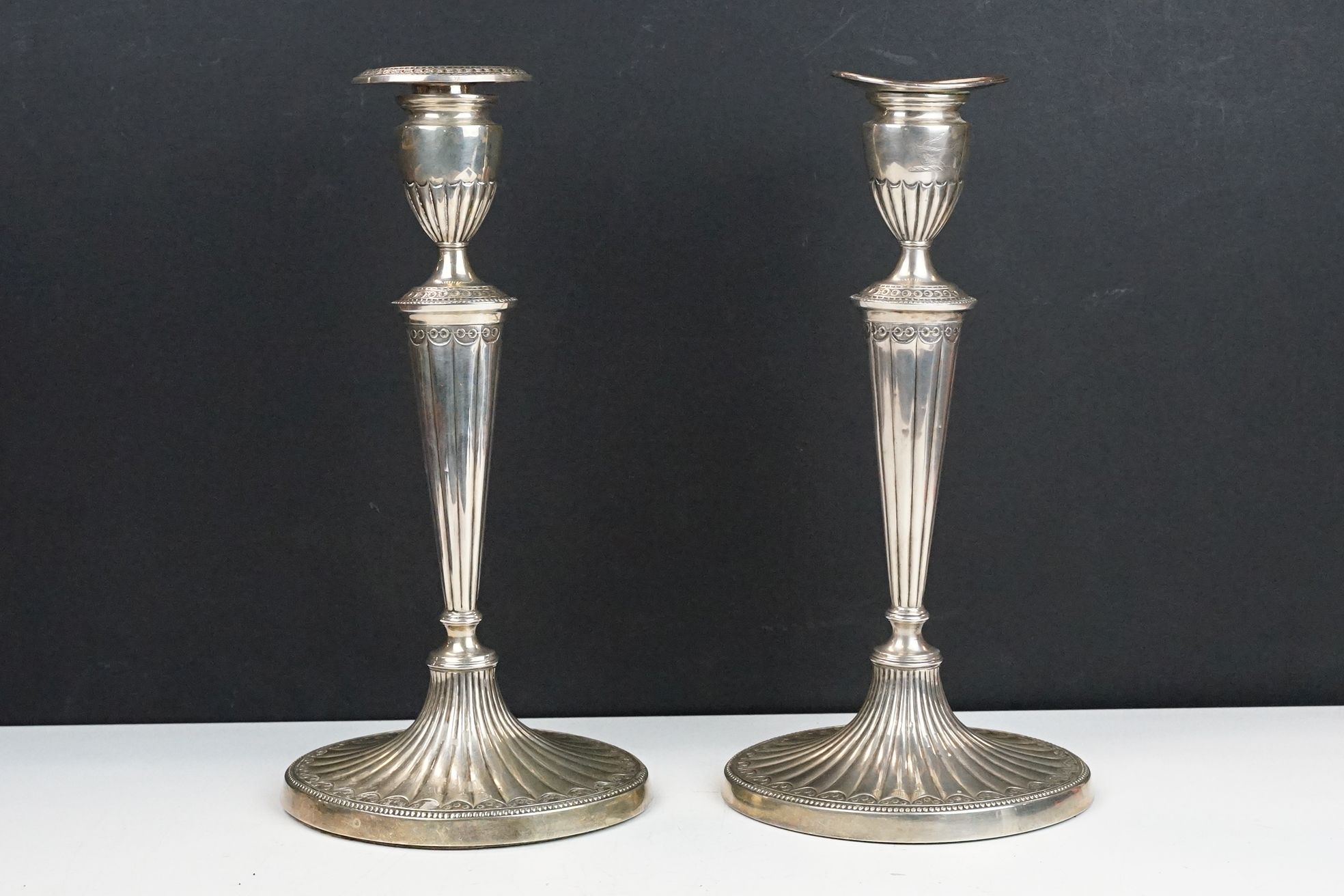 Pair of George III silver hallmarked candlesticks having urn shaped tops with tapering gadrooned