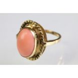 18ct gold and coral ring being set with a central oval coral cabochon within a sunburst mount.
