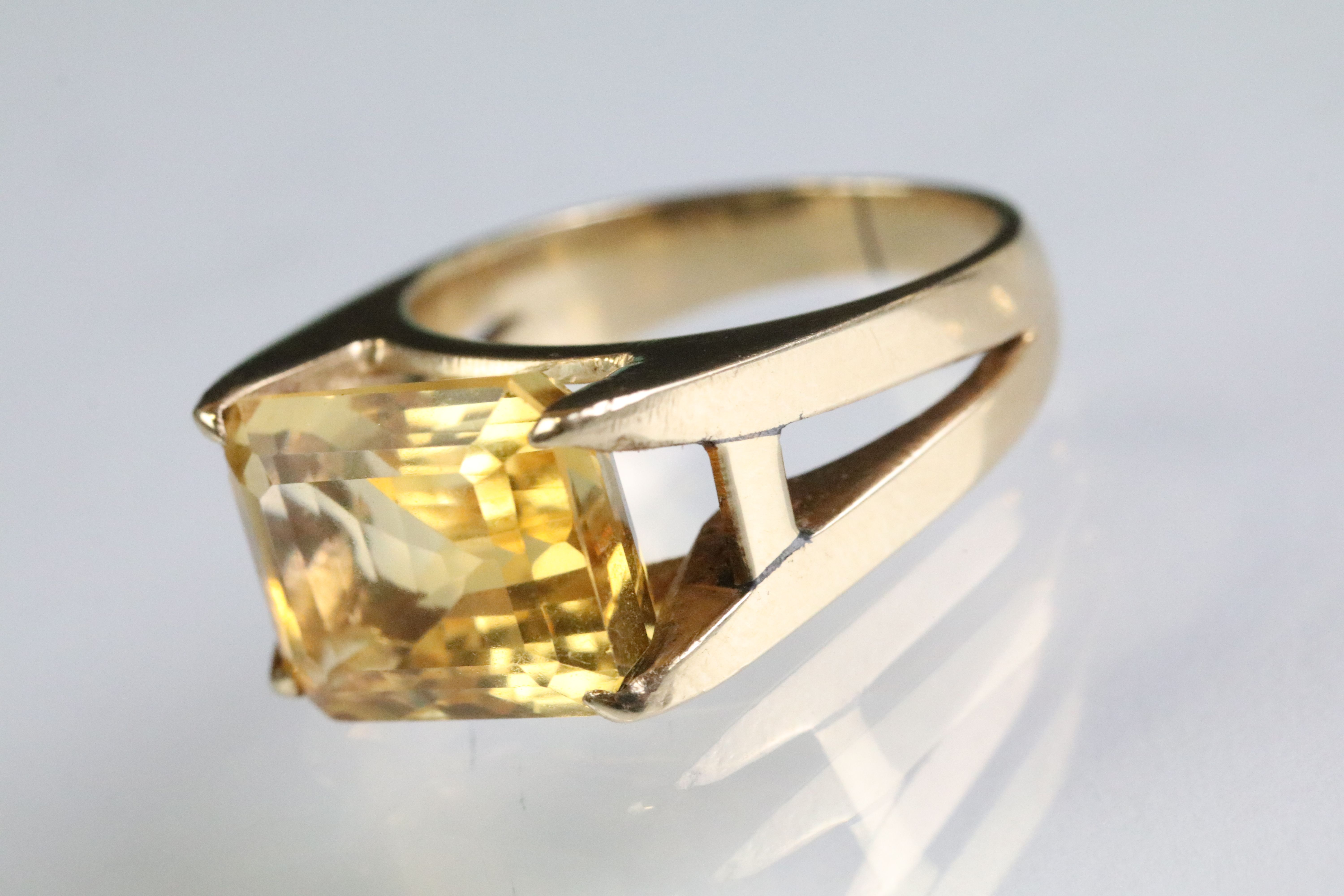 Vintage citrine solitaire ring being set with a step cut citrine in an open four claw setting.
