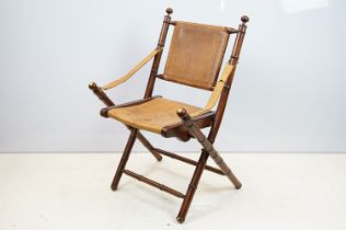 20th century mahogany campaign style chair, the frame carved to simulate bamboo with tan leather,