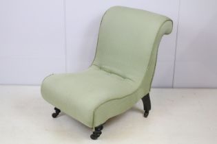 Edwardian nursing chair, with scroll back, upholstered in green on turned tapering legs and castors,