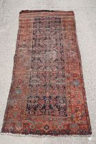 Middle Eastern red ground carpet of geometric design, 310 x 142cm