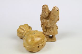 Two Chinese carved wooden netsuke to include a figure of an oriental man holding fish.