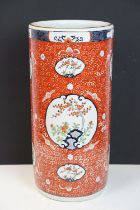 Chinese porcelain stick stand decorated in enamels with panels of blossom trees on a red ground with