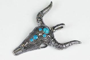 A large silver pendant in the form of a bull's skull set with blue cabochons, marked 925 to the