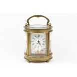 An antique French miniature carriage clock, brass cased with beveled glass panels, decorative Cherub