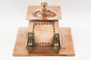 Arts and Crafts Copper Square Inkwell, the hinged lid opening to a ceramic inkwell, pen hooks to