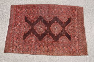 Middle Eastern red ground carpet, with two central medallions within geometric borders, 216 x 140cm