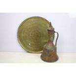 Large antique Eastern copper jug, together with a large brass charger with bands of repeating