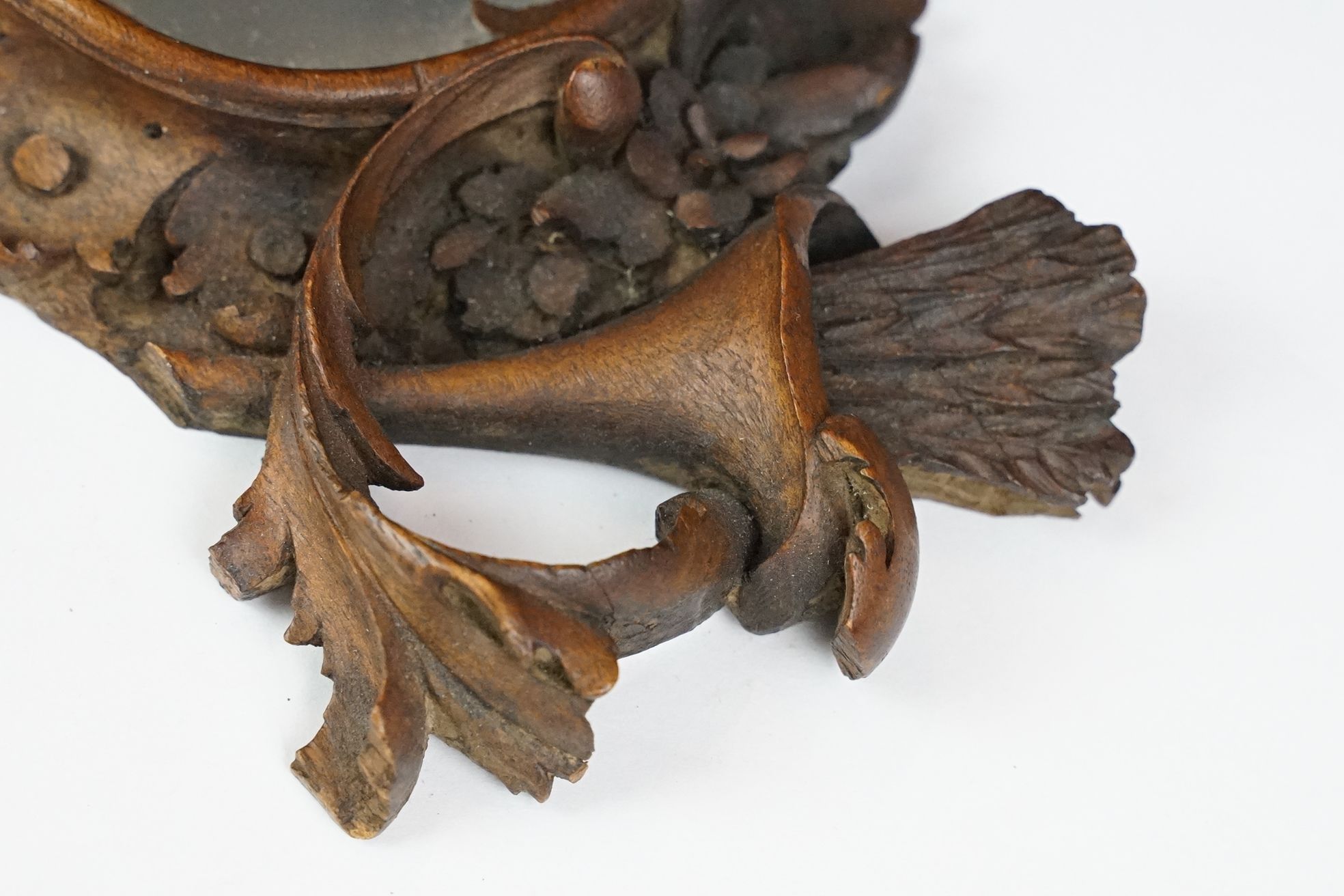 An antique carved wooden Black Forest hand mirror with foliate decoration. - Image 4 of 5