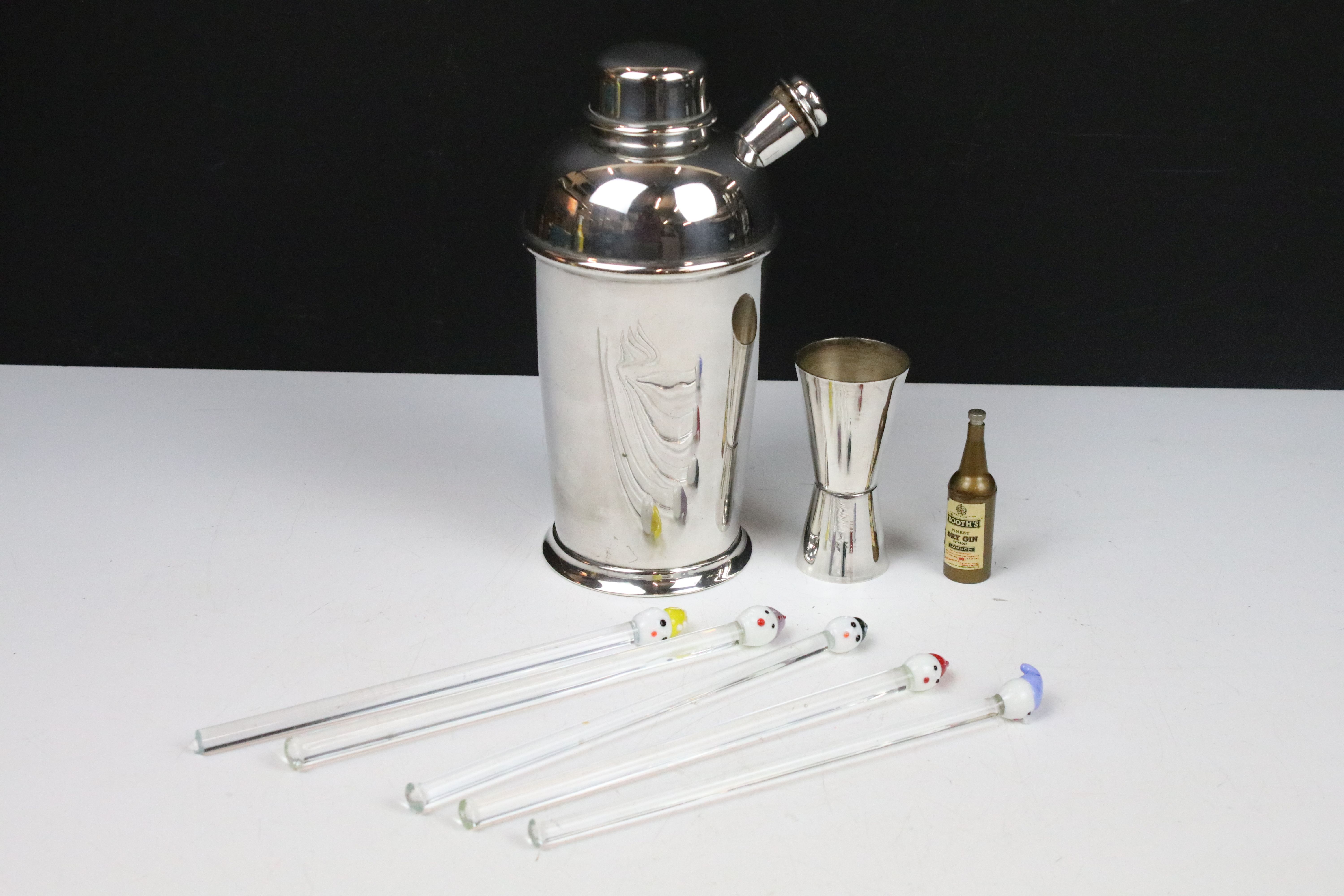 An early to mid 20th century silver plated cocktail shaker together with measuring cup and a set