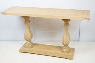 John Lewis pale oak console table of rectangular form over two baluster supports and plinth base,