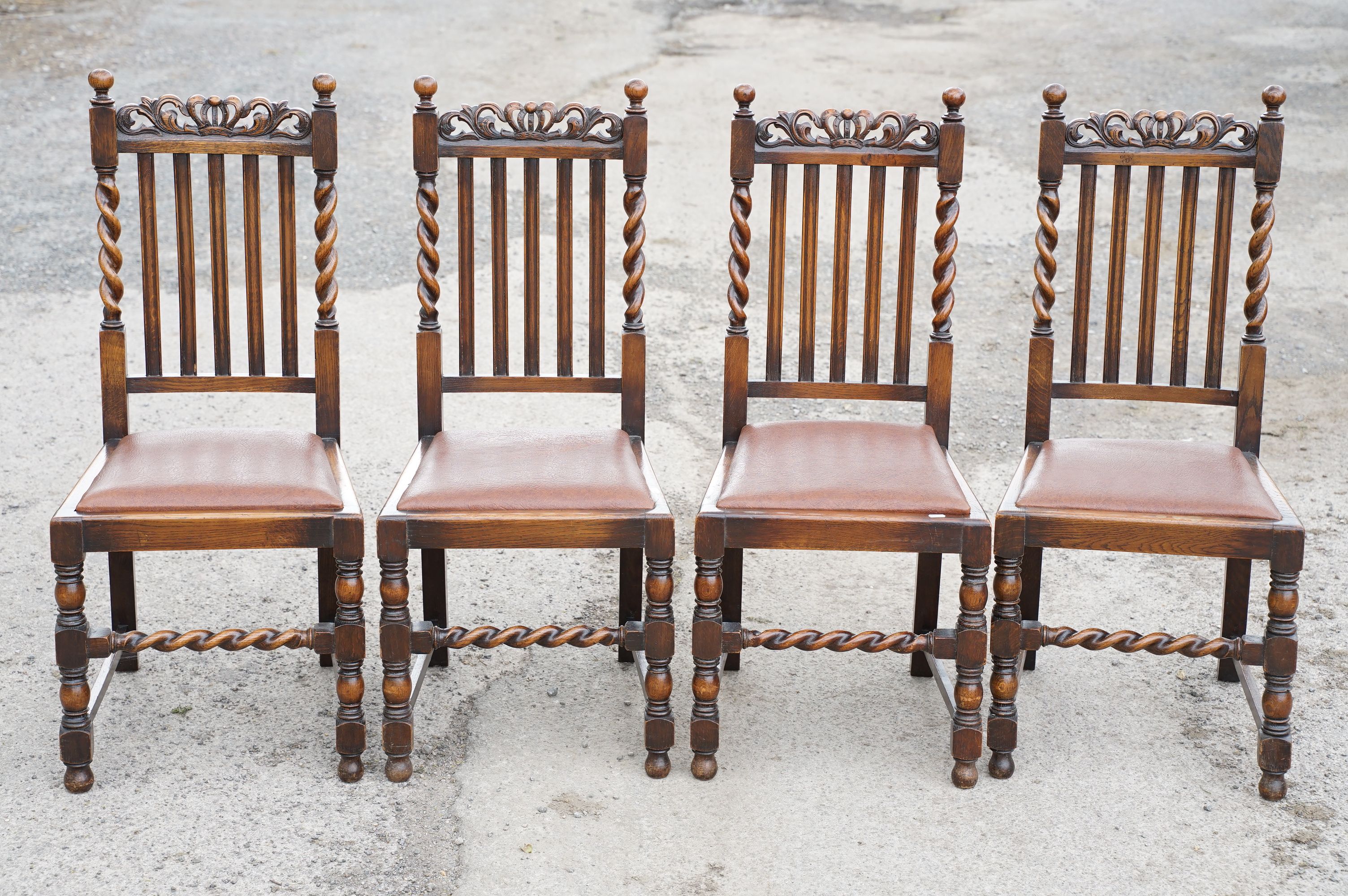 Set of four oak dining chairs with barley twist supports and carved crown details to backs, with