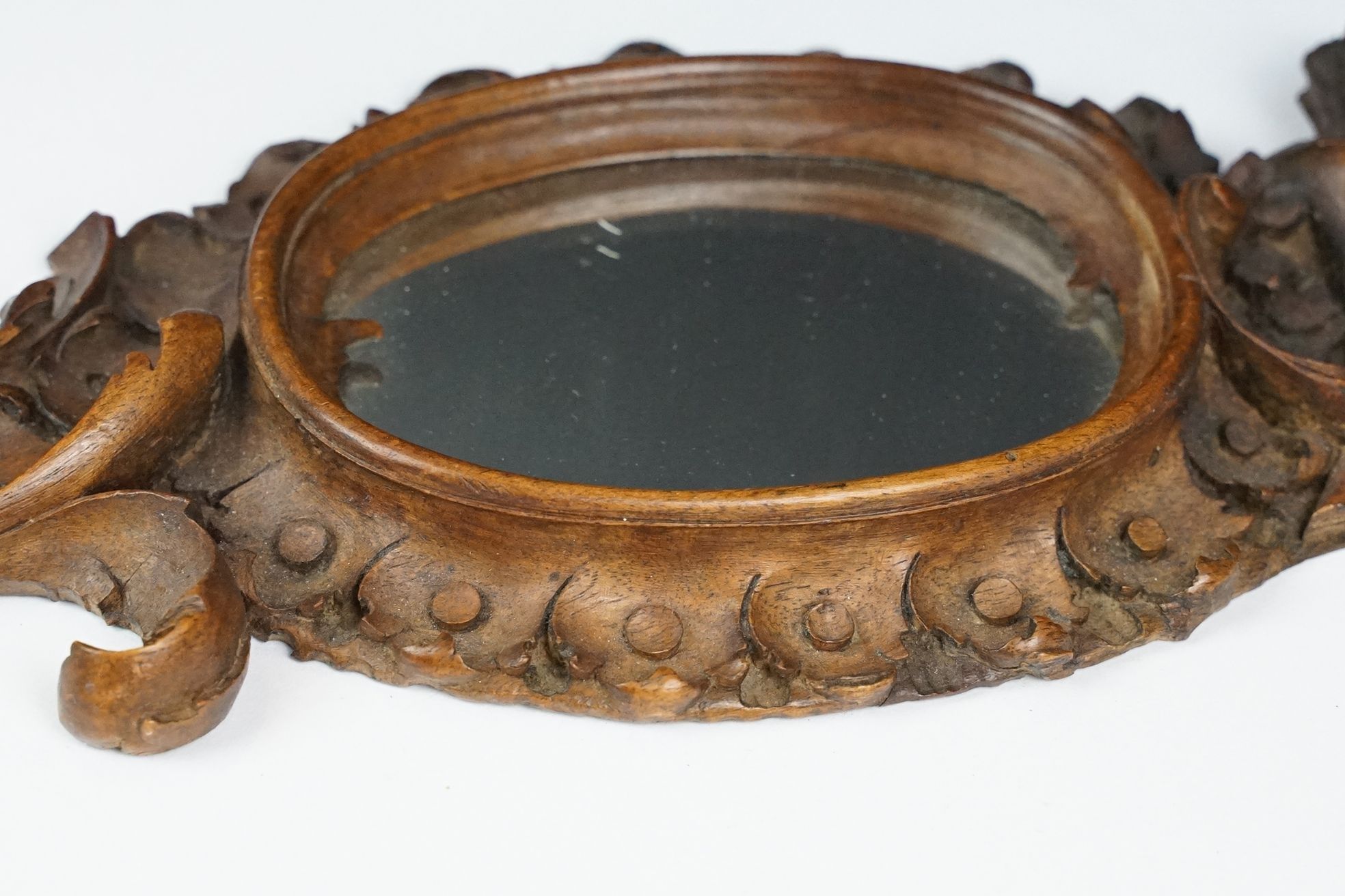 An antique carved wooden Black Forest hand mirror with foliate decoration. - Image 2 of 5