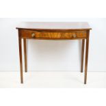 Early 20th century mahogany side table with bow front and single drawer on square legs, 75cm high