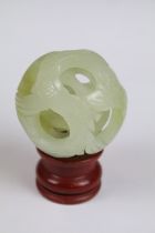 Jade Puzzle Ball carved with a fish design comprising three layers plus a central ball, 6cm wide, on