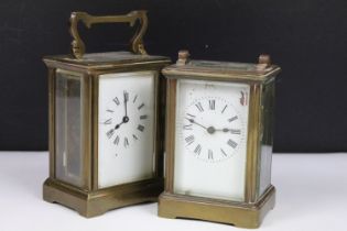 Two vintage brass cased carriage clocks with beveled glass panels and white enamel dials.