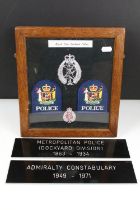 A framed group of Royal New Zealand Police badges together with two police signs.
