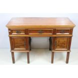 Early 20th century kneehole desk with an arrangement of three drawers above two cupboard drawers