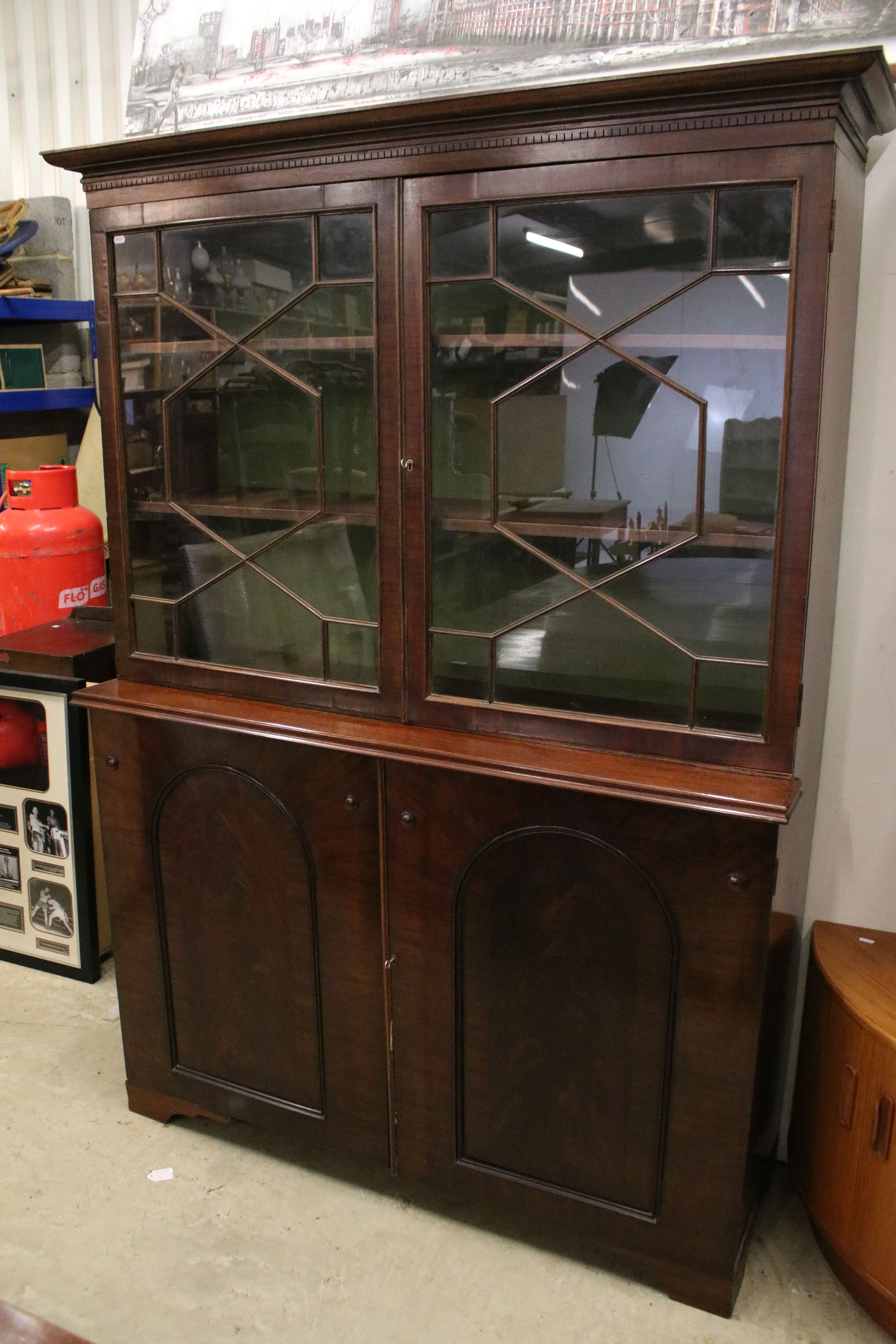 Early 20th century mahogany breakfront bookcase, the upper section with dentil moulding above