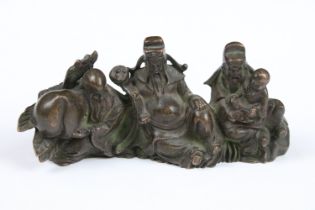 An ornamental Chinese bronze of three Chinese Buddha's