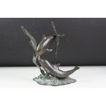 Patinated bronze sculpture of two dolphins amongst sea grasses, 20cm high