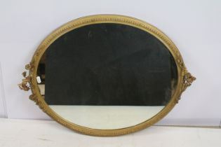 Oval gilt mirror moulded with flowers, berries and leaves, 67 x 38cm