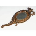 An antique carved wooden Black Forest hand mirror with foliate decoration.