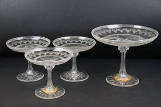 Four 19th century cut glass tazzas with repeating decoration and gilt detail, each raised upon a