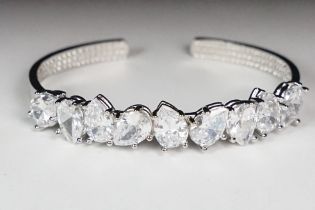 A ladies silver open ended cuff bangle set with nine clear teardrop stones, marked 925 to the verso