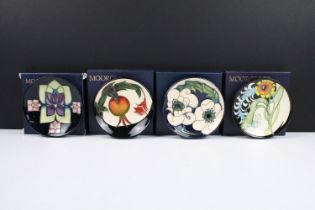 Four Moorcroft dishes each having tube lined floral designs to include Plume, Snow Song, Violet