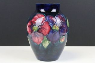 Moorcroft Clematis vase having a navy blue ground with tube lined florals. painted signature to