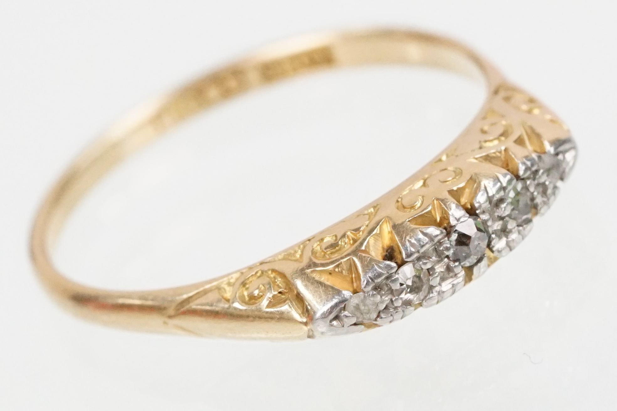 Early 20th Century 18ct gold and diamond ring set with five old cut diamonds in a scrolled