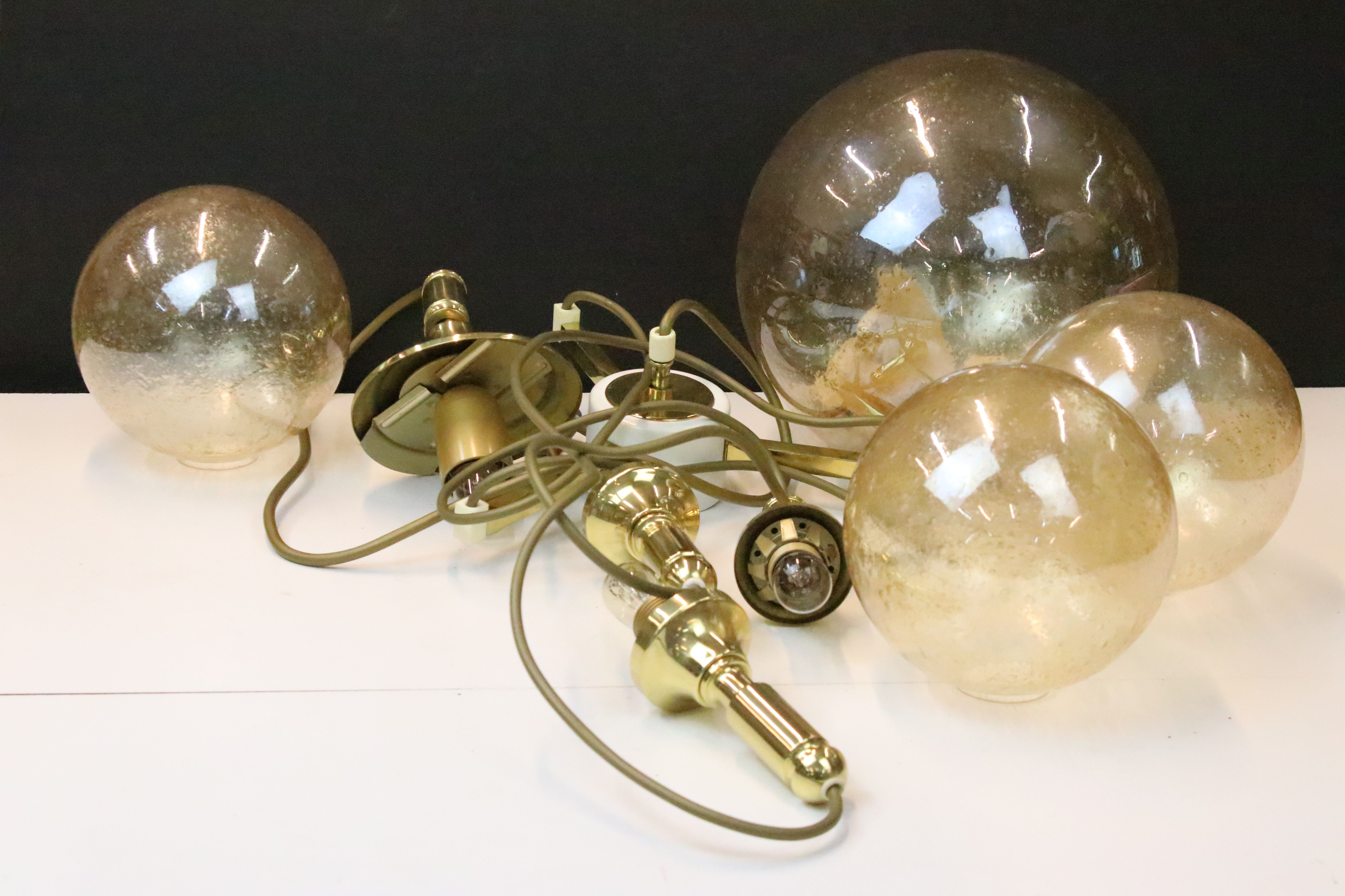 Mid century 1970s cascade pendant brass globes hanging lamp comprising of four spheres in