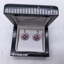 c1970's pair of ruby and diamond circular earring, a cluster of diamonds to the outside boarder, the