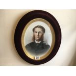 Oval photographic portrait set in red velvet frame