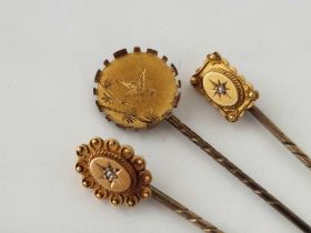 Three antique gold stick pins 2 marked 15ct gold and set with a diamond and the 3 with a Japanese