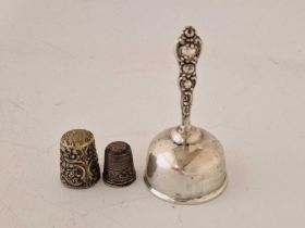 A small table bell and two thimbles