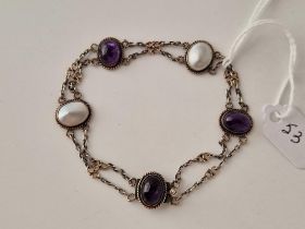 AN ARTS AND CRAFTS QUALITY SILVER AND GOLD BRACELET, SET WITH CABOCHON AMETHYST AND MOP
