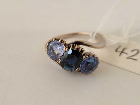 A three stone dark blue and light blue gemstone ring, set in gold size N, 3.6 g