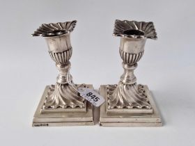 A pair of candlesticks the square bases with swirl decoration and detachable nozzles, 4.5" high,