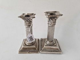 A small pair of candlesticks with square bases, fluted stems, Birmingham 1897