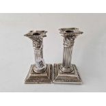 A small pair of candlesticks with square bases, fluted stems, Birmingham 1897