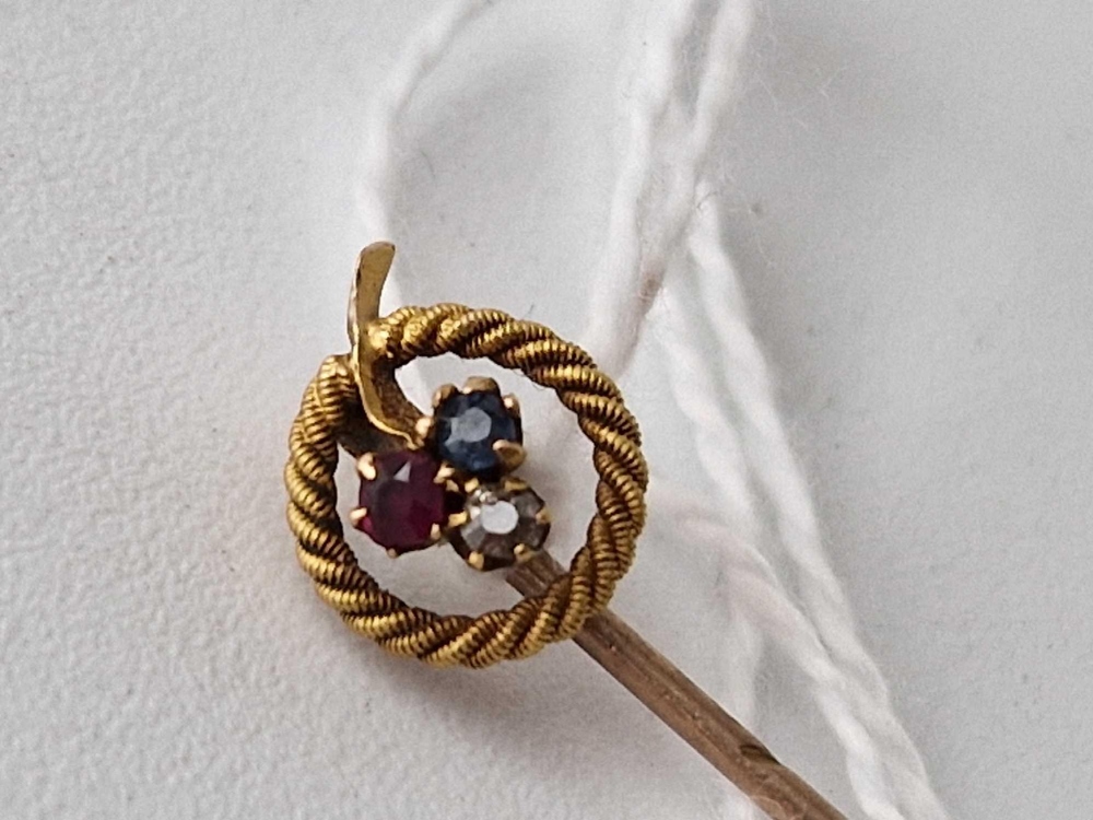 Edwardian 15ct stamped stick pin set with sapphire, ruby and diamond in a clover design