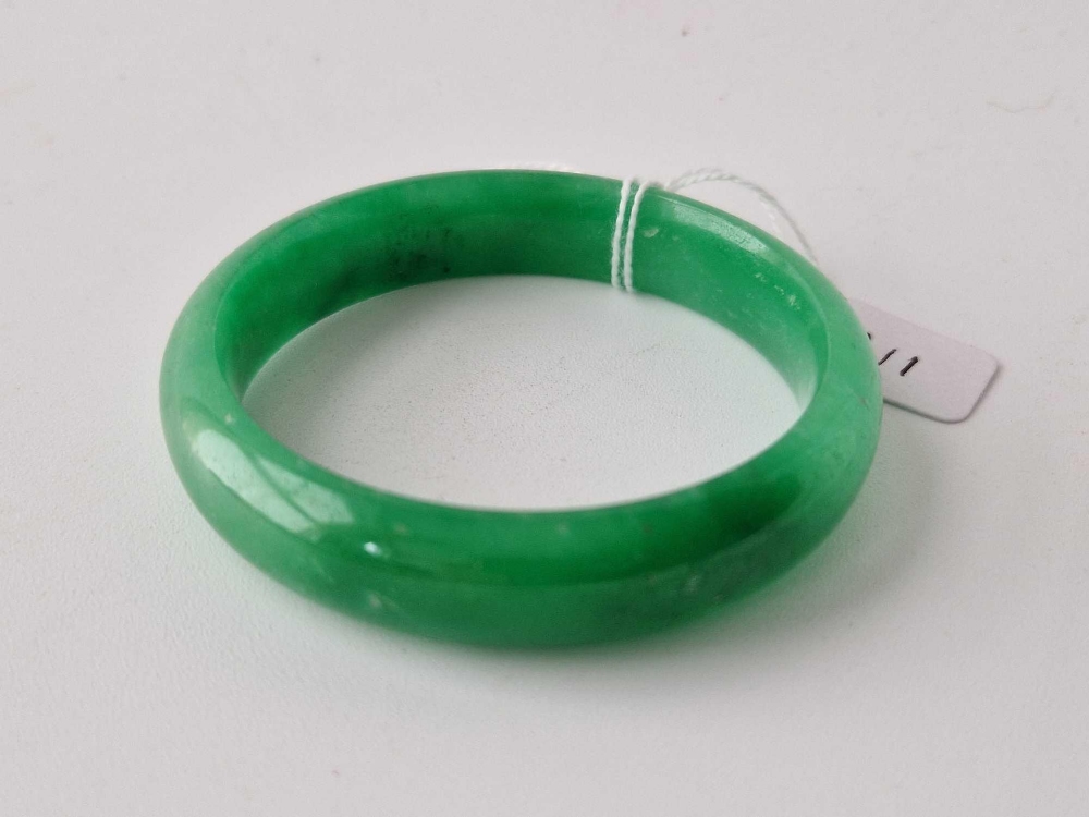 A ANTIQUE GREEN JADE BANGLE