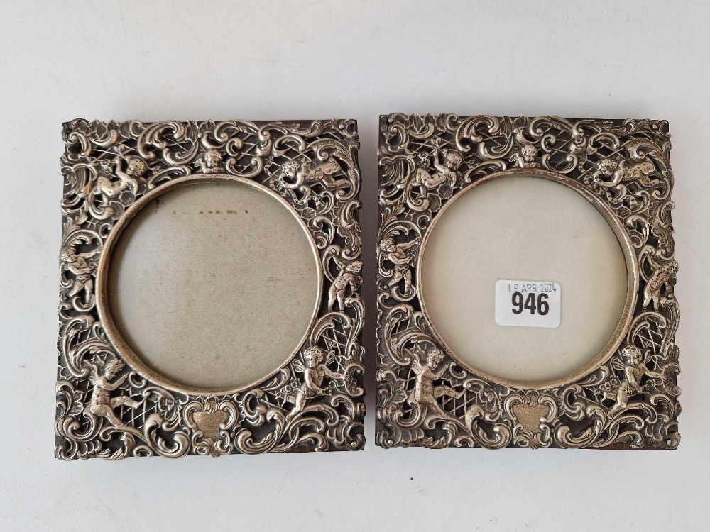 A good pair of decorative photo frames pierced and embossed with scrolls and cherubs, 6" high,